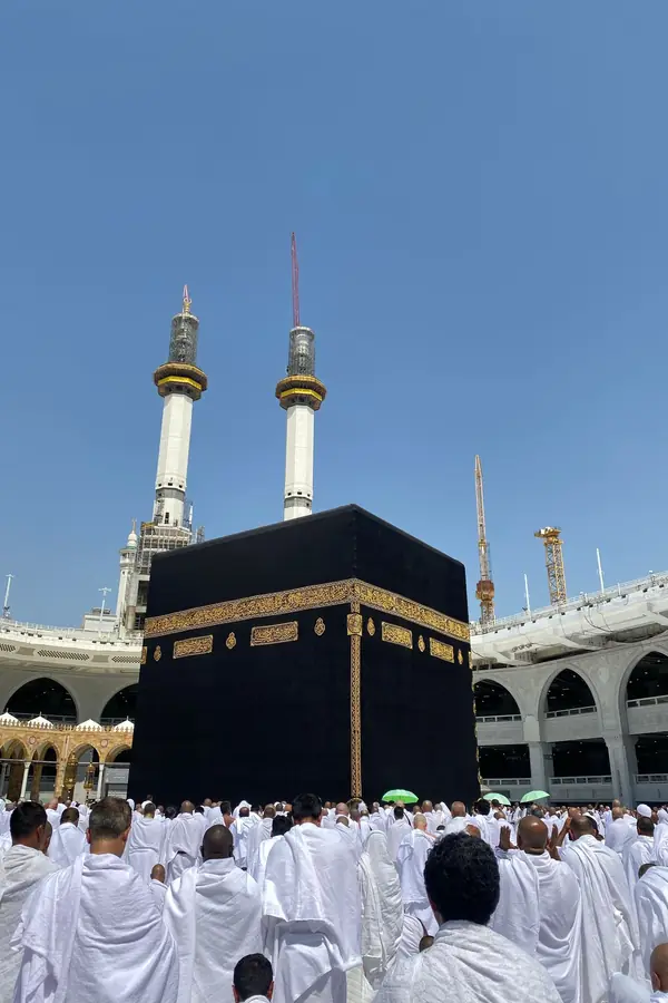 Kâbe önünde dua eden beyaz giysili hacılar